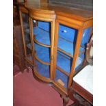 A good early 20th century mahogany bowfront single door china display cabinet, having twin short