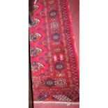 A Persian woollen red ground Bokhara rug, 214 x 144cm