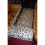 An Edwardian walnut framed and floral upholstered chaise-longue