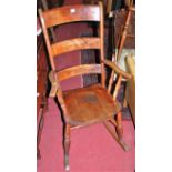 An early 20th century elm seat and beech bar ladderback rocking elbow chair