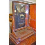 An early Victorian mahogany swing toilet mirror raised on scroll end supports, width 62.5cm