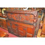 An antique joined and relief carved oak court cupboard having twin upper and lower doors, width