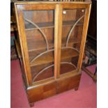 A 1930s oak double door glazed bookcase, having twin lower cupboard doors, w.93cm