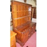 A 1930s relief carved oak dresser, having two-tier open plate rack over base fitted with twin