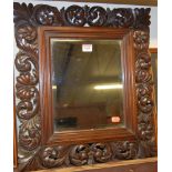 A bevelled wall mirror in leaf carved hardwood frame, 51 x 46cm
