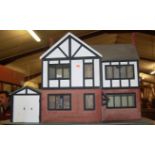 A mock-Tudor two-storey dolls house, having hinged openings, with various furniture and