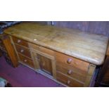 A Victorian pine round cornered sideboard fitted with seven drawers and a single central cupboard