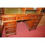 A reproduction yew wood and gilt tooled green leather inset twin pedestal writing desk, w.122.5cm