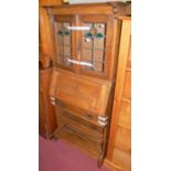 An Arts & Crafts oak students bureau having twin lead glazed upper doors, width 78cm