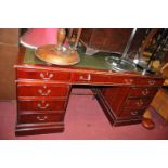 A reproduction mahogany and gilt tooled green leather inset twin pedestal writing desk, w.166cm