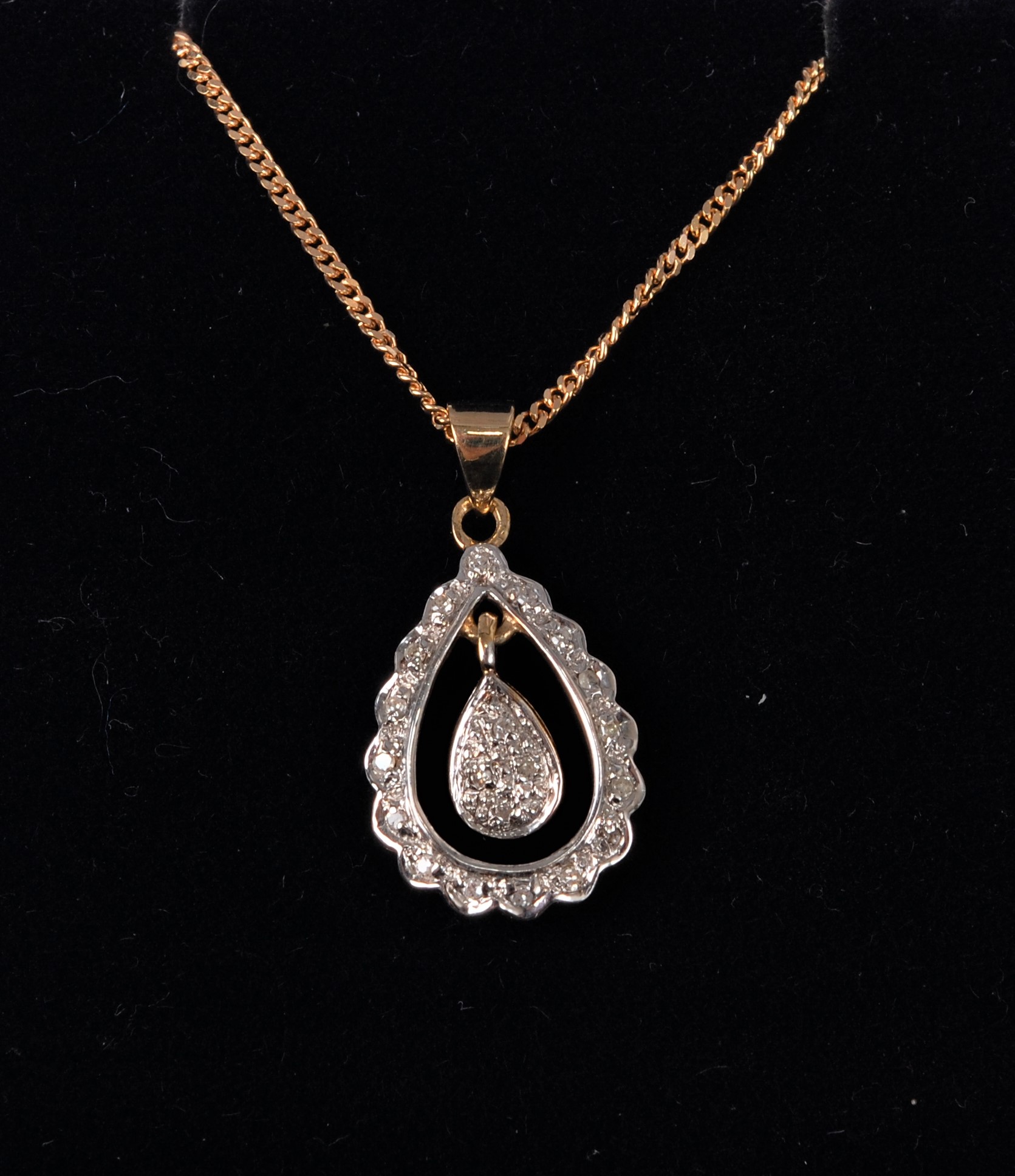 A 9ct diamond pendant, the open pear shaped pendant set with small round diamonds, in a white gold