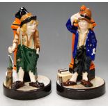 A pair of W.H. Goss porcelain figures of peasant children against a pillar-box, printed backstamp,