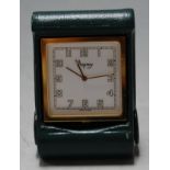 A small gilt metal cased travel clock in green leather outer case by Asprey