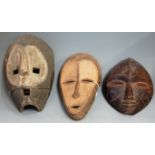 Three mid-20th century African masks, to include Kumu (Democratic Republic of Congo), Lega (also