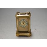 A miniature lacquered brass cased carriage clock having enamelled chapter ring and visible