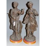 A large early 20th century spelter figure of a lady carrying a wheatsheaf together with one other