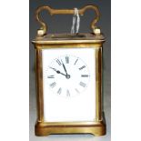 An mid 20th century lacquered brass cased carriage clock having enamelled dial with Roman numerals