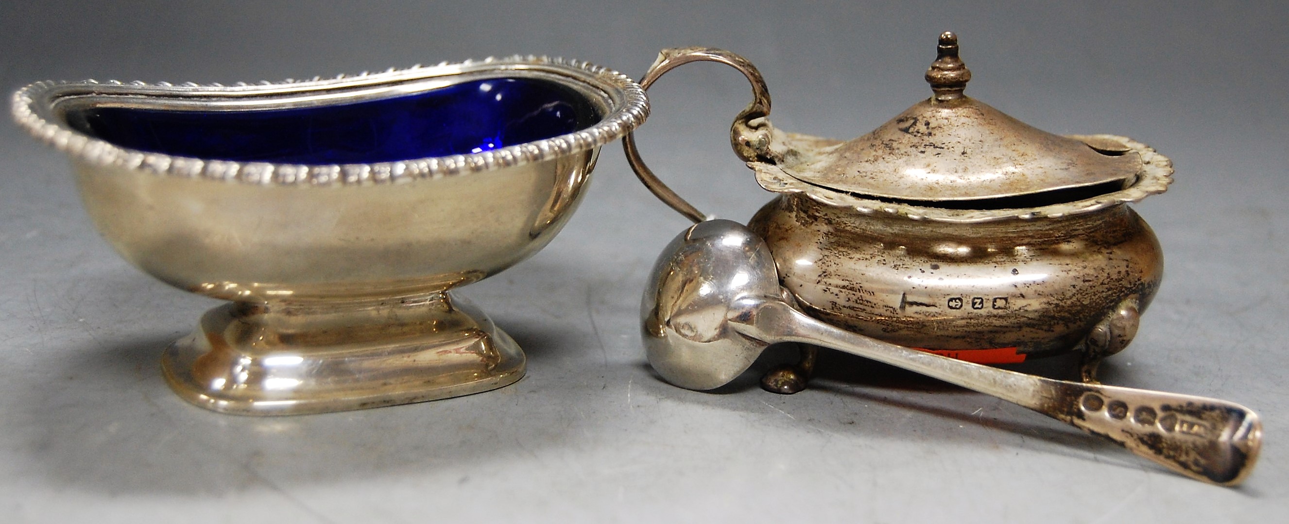 A silver boat shaped mustard, with hinged cover and associated spoon; together with a silver