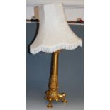 An early 20th century gilt brass table lamp, having acanthus leaf decoration to tripod base with paw