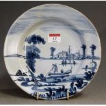 An 18th century Dutch delft blue and white plate, depicting figures amidst river landscape (