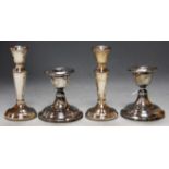 A pair of silver dwarf candlesticks on loaded bases (a/f); and a pair of modern silver and loaded