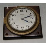 A brass cased 8 day clock having a silvered dial with Arabic numerals on wooden plinth