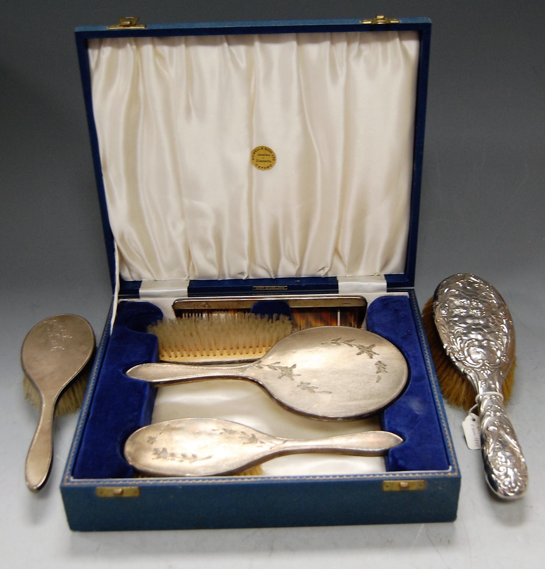 A cased engine turned silver four-piece dressing table set, comprising hairbrush, hand mirror,