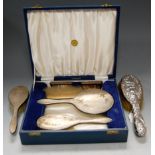 A cased engine turned silver four-piece dressing table set, comprising hairbrush, hand mirror,