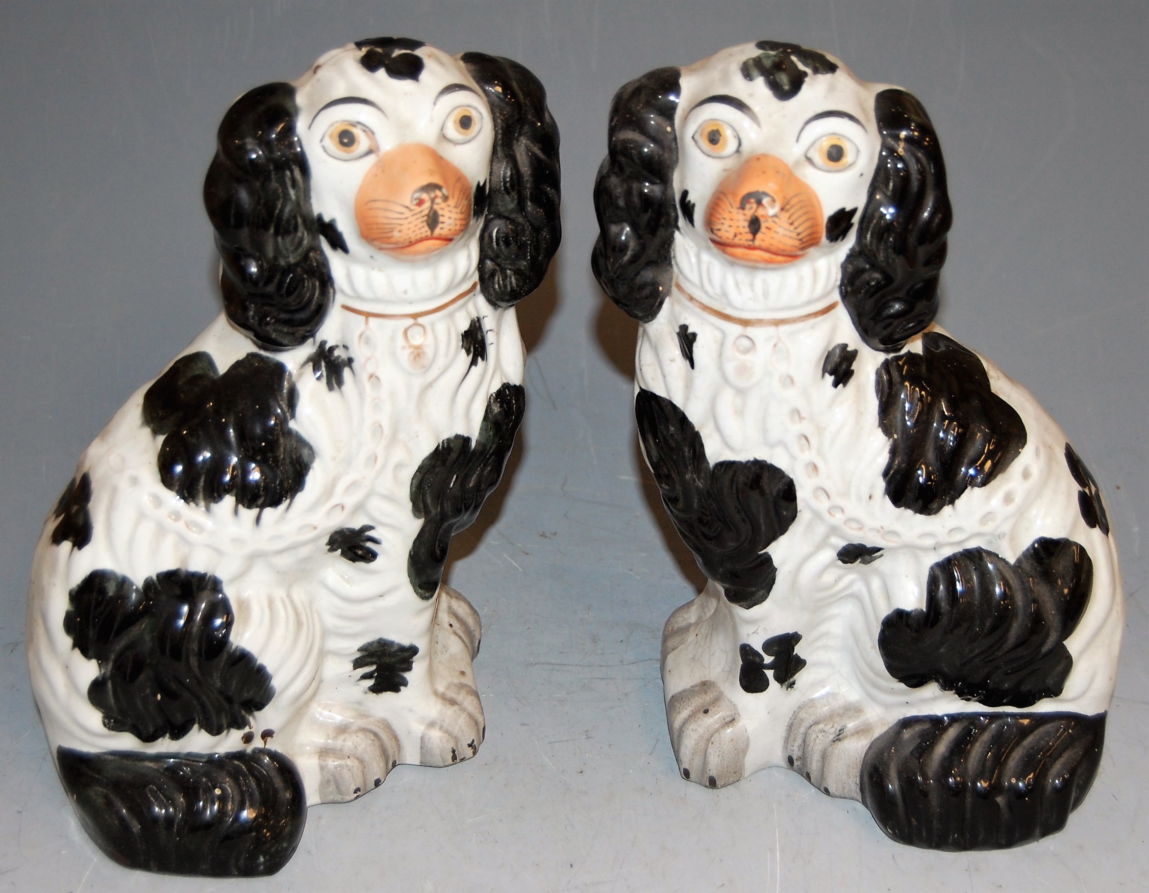 A pair of Victorian Staffordshire figures of seated spaniels, h.27cm