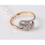 An 18ct and platinum Art Deco style ring, the three small single cut diamonds set in a plaque of