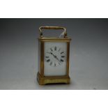 A mid 20th century lacquered brass cased carriage clock having enamel dial with Roman numerals,