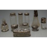 A collection of Victorian and later silver topped dressing table jars