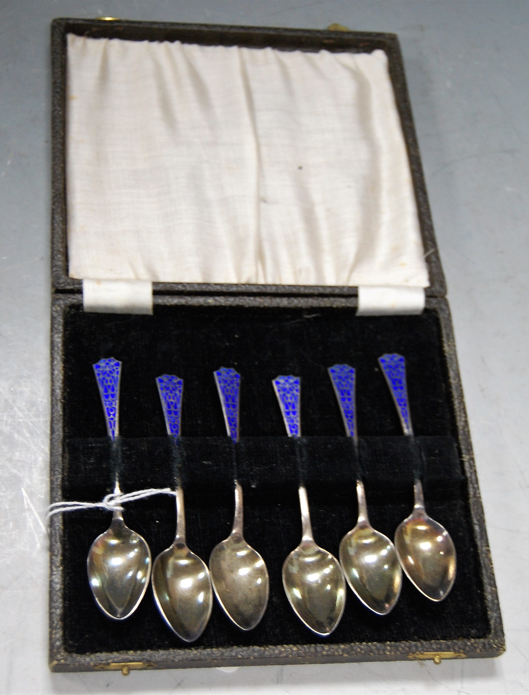 A cased set of six silver and enamelled teaspoons