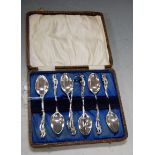 A cased set of six silver teaspoons, with C-scroll chased handles, and a matching pair of sugar