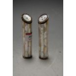 A matched pair of mother of pearl and white metal mounted cruets of cylindrical form