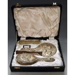 A cased silver four-piece dressing table set, comprising hairbrush, clothes brush, hand mirror and
