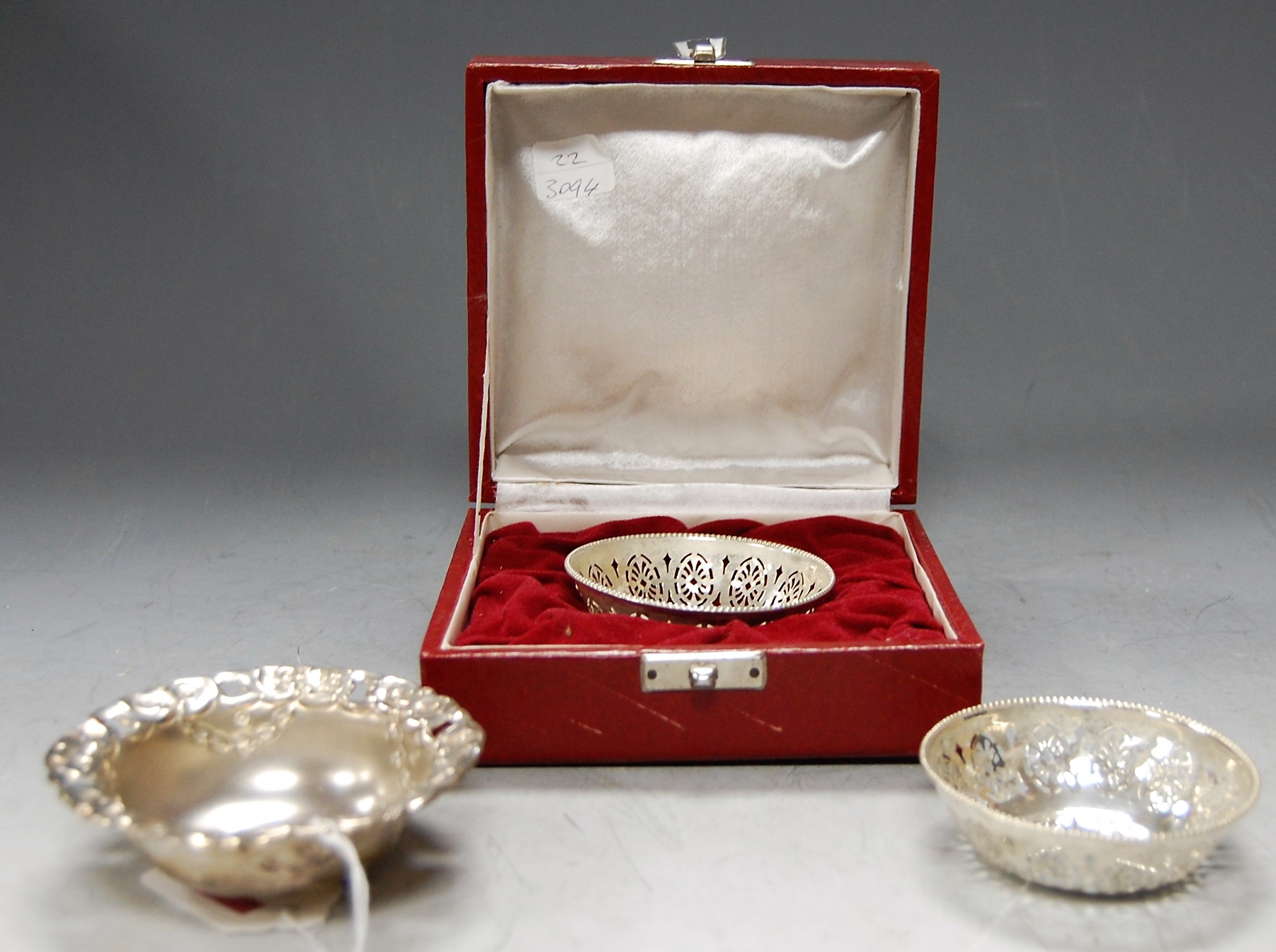 A cased pierced and embossed white metal bonbon dish, stamped Silver; together with a pair of