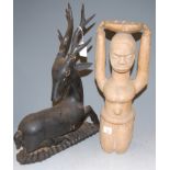 An African carved softwood fertility figure; together with a carved and ebonised softwood deer (2)
