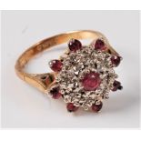 An 18ct ruby and diamond cluster ring, the central ruby surrounded by small round diamonds and an