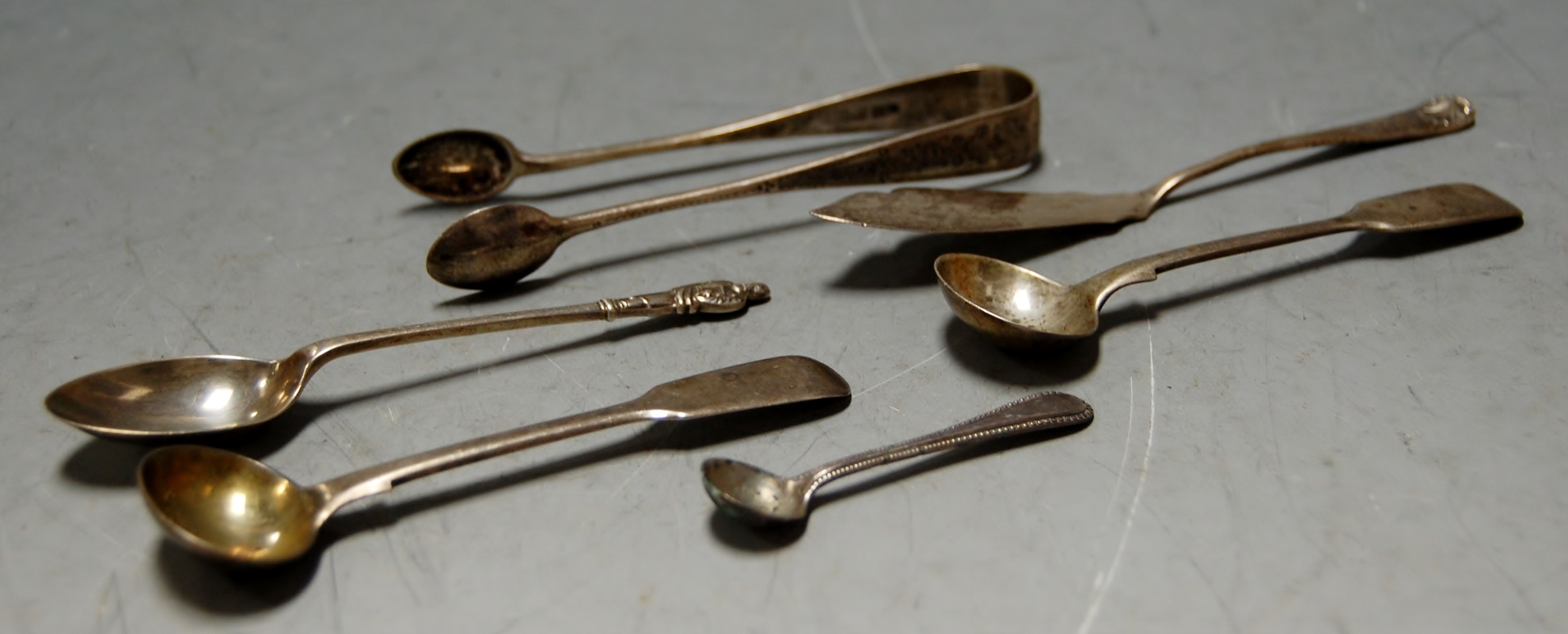 A small collection of loose 19th century and later silver flatwares to include salt spoon, sugar