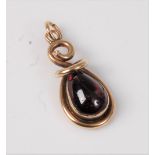 A garnet pendant, the pear shaped garnet collet mounted with a twisted hanging bale, all in unmarked