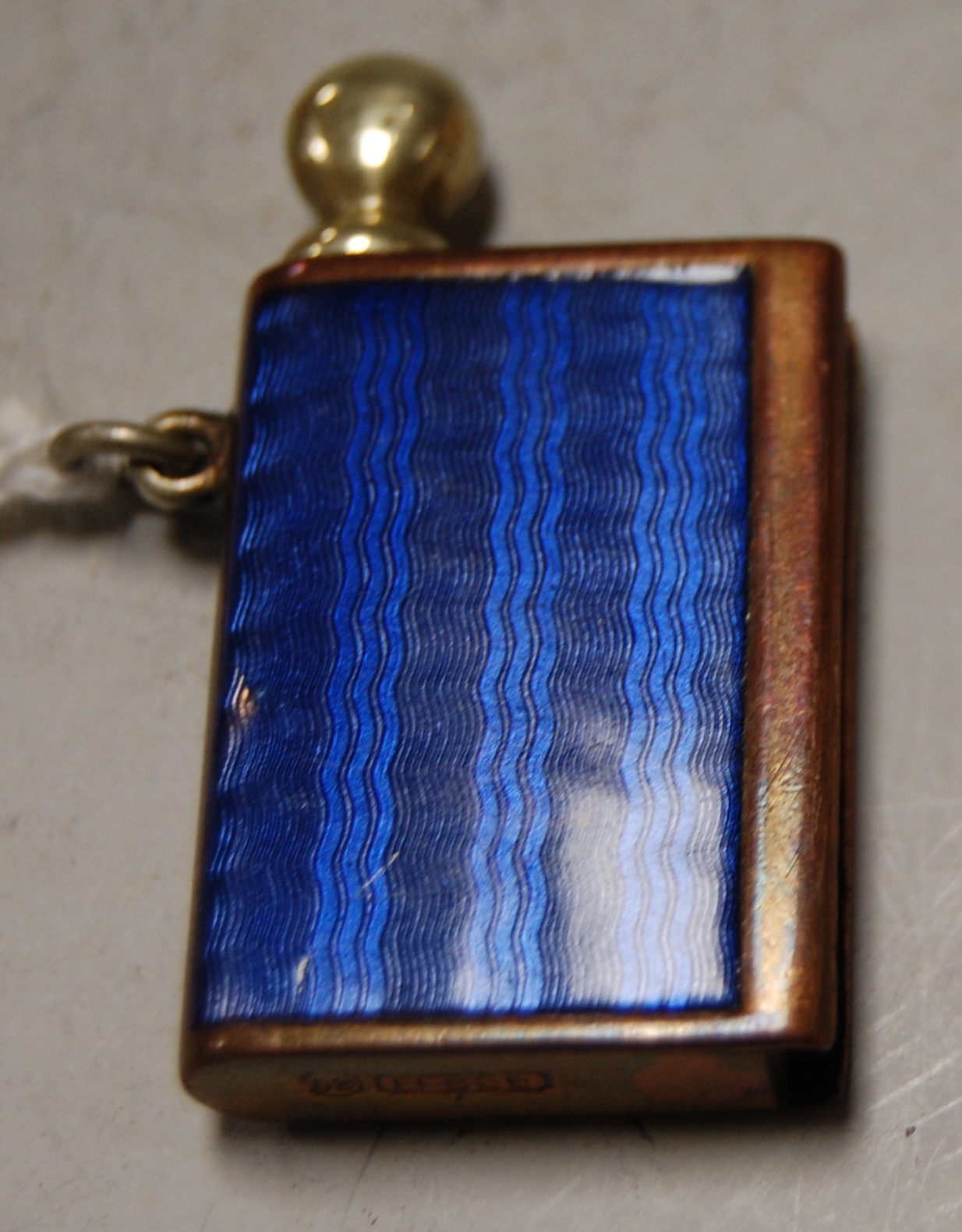 A blue enamel vesta/striker, of book shape with brass wick/taper, stamped '68 EFBEE', 3.5cm high