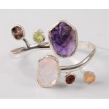 A multi gem set silver cuff style bangle, the rustic cut gemstones comprised of amethyst, rose