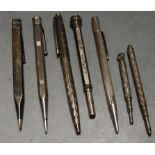 An engine turned silver propelling pencil together with various other silver and steel propelling