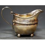 An Edwardian silver cream jug on ball feet, 5.5oz, London 1906, h.9.5cm