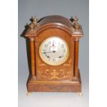 A late 19th century rosewood and satinwood inlaid cased table clock, having silvered dial with