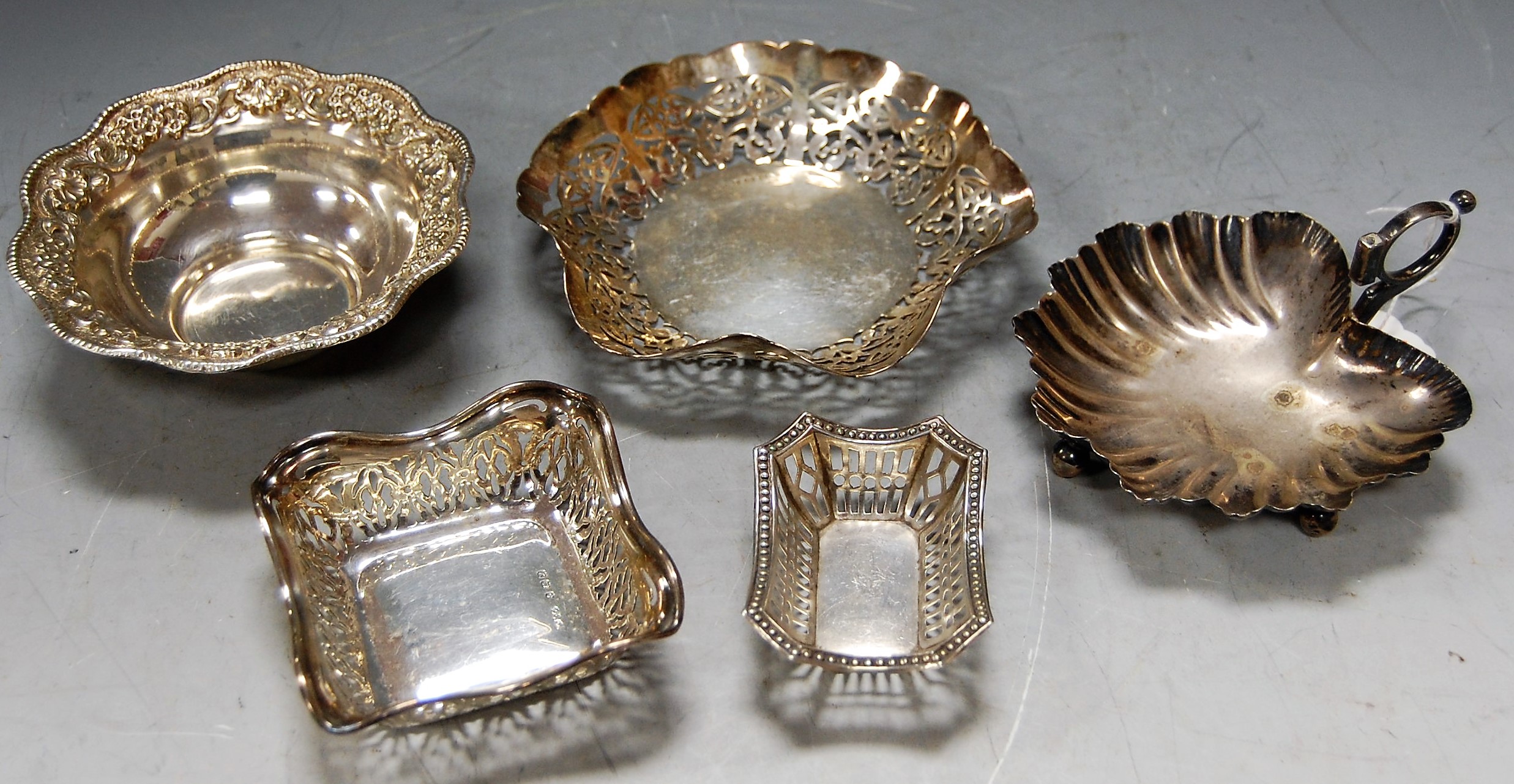 A white metal embossed bonbon dish, stamped Silver; a Mappin & Webb shell shaped bonbon dish; and