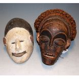 An African carved softwood tribal mask; and one other painted example (2)
