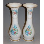 A pair of opaque glass trumpet form vases, each painted with wildflowers and heightened in gilt, h.