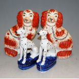 A pair of Staffordshire seated spaniels, each having sponged iron-red decoration, h.25cm; together